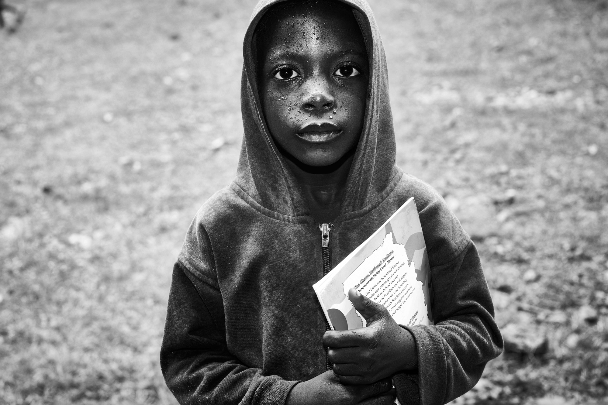 Edem from Dzogbedze cradling his precious books.