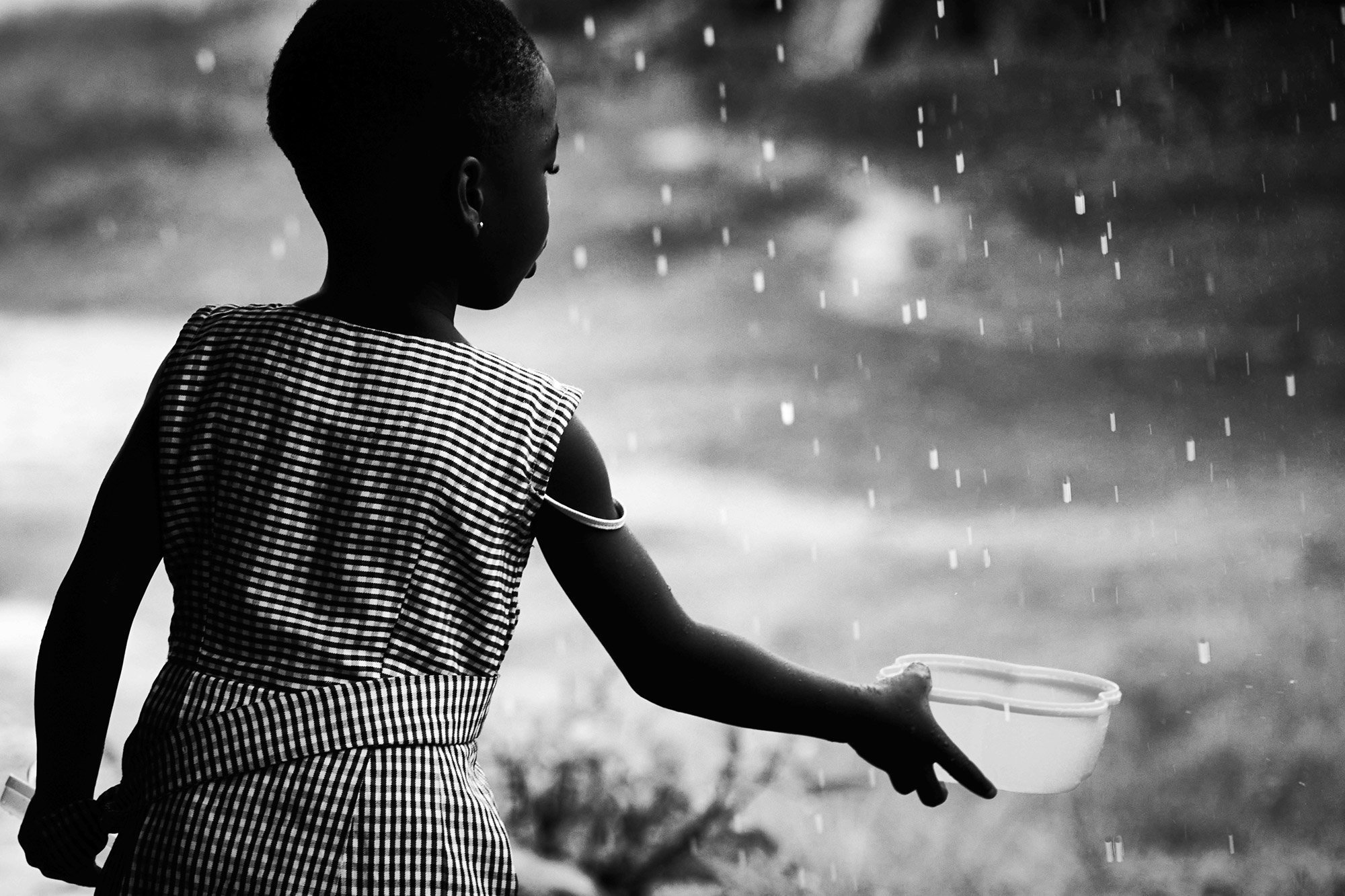 Mavis collecting rainwater in Anfoega Bume. Now she has clean water all year round from the water system  that Community Action Ghana installed.